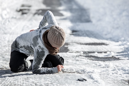 woman grabbing lower back in pain from slipping on ice
